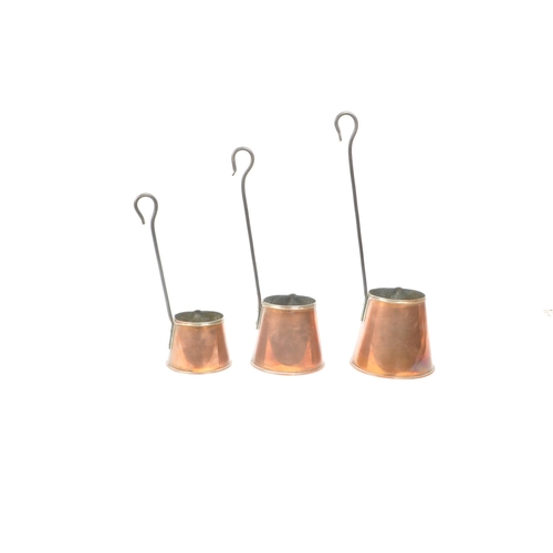 253 - Set of three copper cider measures graduating in size, each with a long hook handle and brass plaque... 