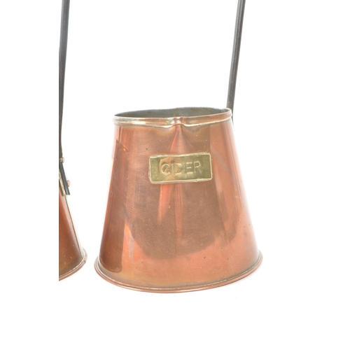 253 - Set of three copper cider measures graduating in size, each with a long hook handle and brass plaque... 