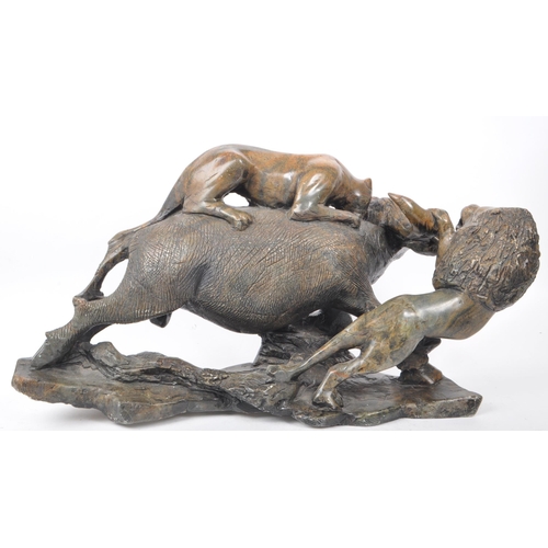 294 - A large believed South African 20th century carved soapstone sculpture of lions slaying a buffalo. T... 