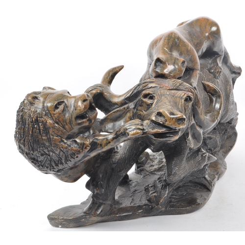 294 - A large believed South African 20th century carved soapstone sculpture of lions slaying a buffalo. T... 