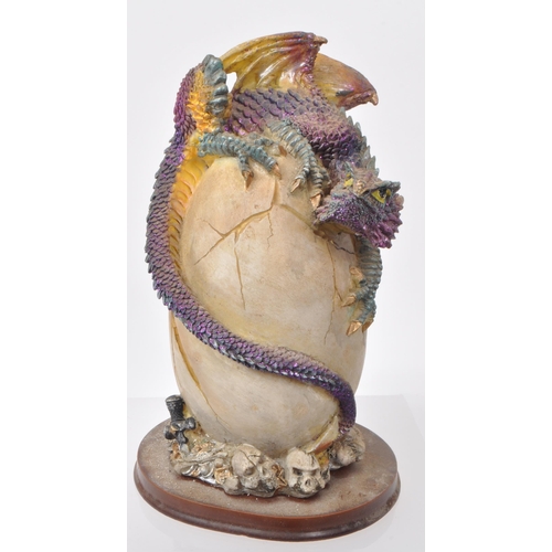 317 - A large collection of contemporary resin dragon figures, mostly depicting dragons hatching out of eg... 