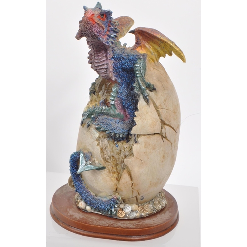 317 - A large collection of contemporary resin dragon figures, mostly depicting dragons hatching out of eg... 