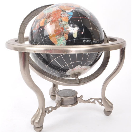 330 - A vintage 20th century gemstone inlaid desktop globe. The globe of black ground featuring precious s... 