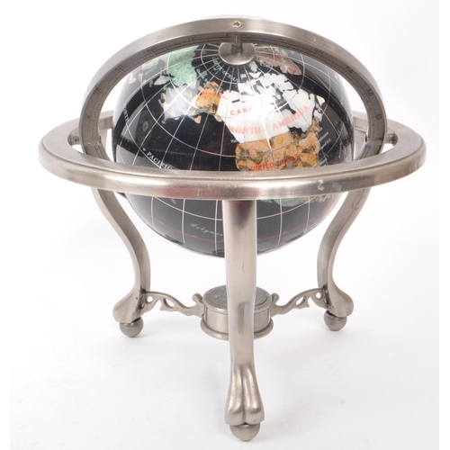 330 - A vintage 20th century gemstone inlaid desktop globe. The globe of black ground featuring precious s... 