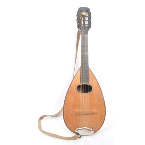 450 - A vintage 20th century bowl back mandolin musical instrument, with a suede strap, 8 strings, and a b... 