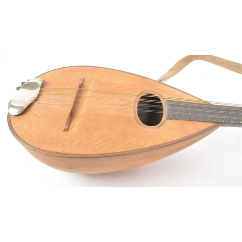 450 - A vintage 20th century bowl back mandolin musical instrument, with a suede strap, 8 strings, and a b... 