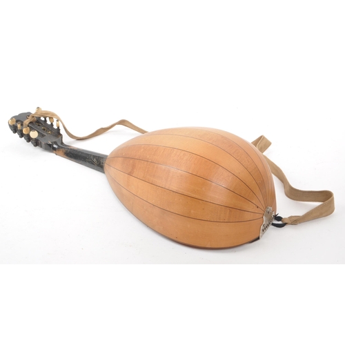 450 - A vintage 20th century bowl back mandolin musical instrument, with a suede strap, 8 strings, and a b... 