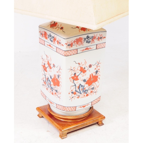 50 - An early 20th century Chinese ceramic imari style lamp, raised on a wooden structure with four short... 