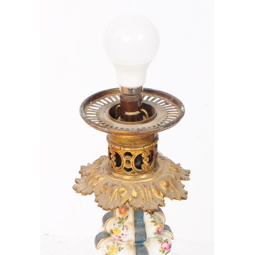 60 - A tall porcelain table lamp with ornate metal head and pale pink lampshade. The porcelain body is de... 