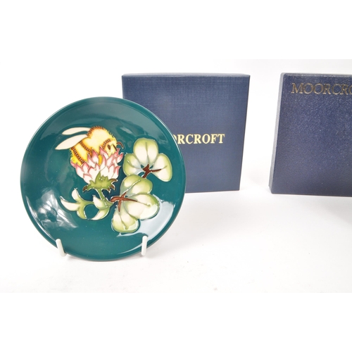 73 - Moorcroft Pottery - Two modern ceramic pin dishes, one in the lily plume pattern and the other bumbl... 