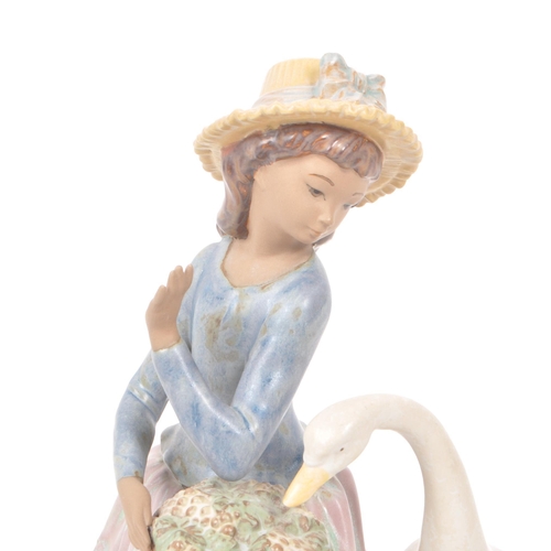 91 - Lladro - A 1979 Spanish porcelain figurine, titled 'Goose Trying to Eat' no. 12312, depiciting a lad... 