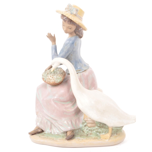 91 - Lladro - A 1979 Spanish porcelain figurine, titled 'Goose Trying to Eat' no. 12312, depiciting a lad... 