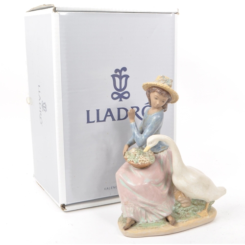 91 - Lladro - A 1979 Spanish porcelain figurine, titled 'Goose Trying to Eat' no. 12312, depiciting a lad... 