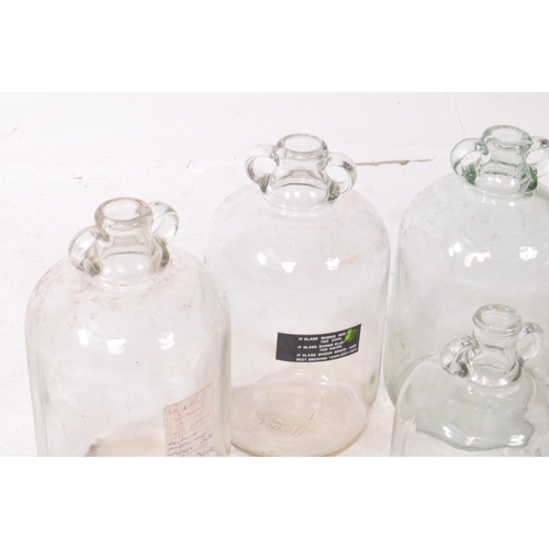 134 - A collection of five vintage 1980s Demijohn glass brewing bottles. One with a label dating 'Septembe... 