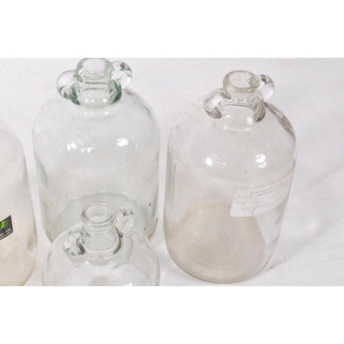 134 - A collection of five vintage 1980s Demijohn glass brewing bottles. One with a label dating 'Septembe... 