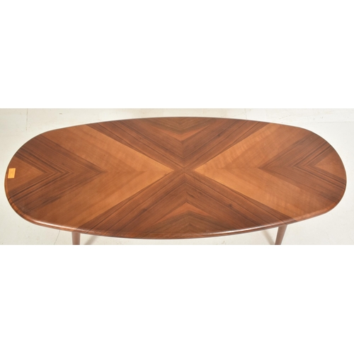 118 - A contemporary designer walnut coffee table / low table. The table having an oval butterfly veneered... 