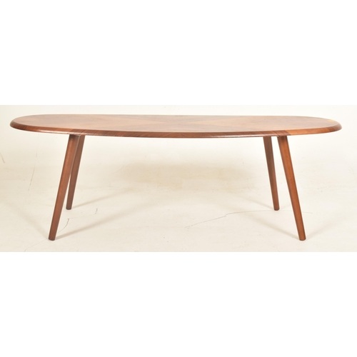 118 - A contemporary designer walnut coffee table / low table. The table having an oval butterfly veneered... 