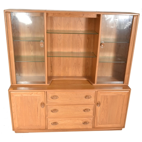 129 - Ercol - Windsor Range - a beech & elm glazed display unit cabinet. The cabinet having a central ... 