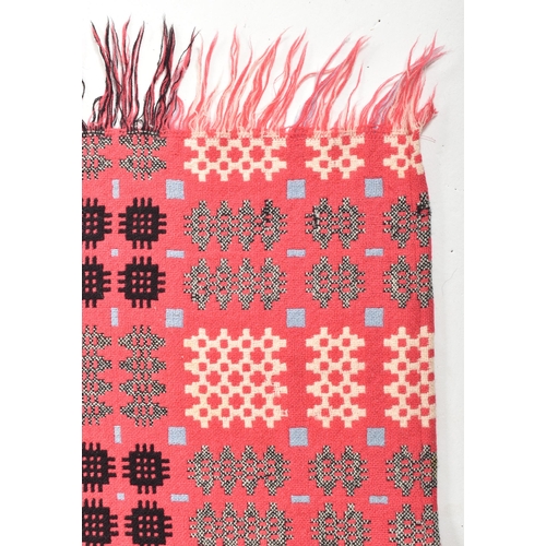 134 - A vintage 20th century hand woollen traditional Welsh blanket. The blanket in hues of hot pink, blue... 