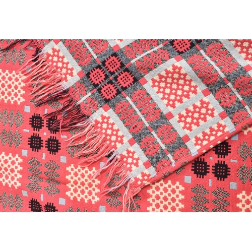 134 - A vintage 20th century hand woollen traditional Welsh blanket. The blanket in hues of hot pink, blue... 