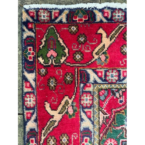 213 - A 20th century Persian Islamic Tabriz floor carpet rug. The carpet having a cream & blue ground ... 