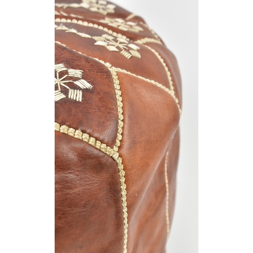 224 - A Moroccan Northern African tan brown leather and white stitching decorative footstool / pouffe. The... 