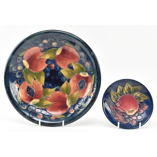 284 - William Moorcroft - Pomegranate design - an early to mid 20th century plate, along with a later trin... 