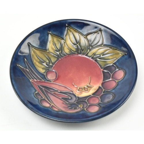 284 - William Moorcroft - Pomegranate design - an early to mid 20th century plate, along with a later trin... 