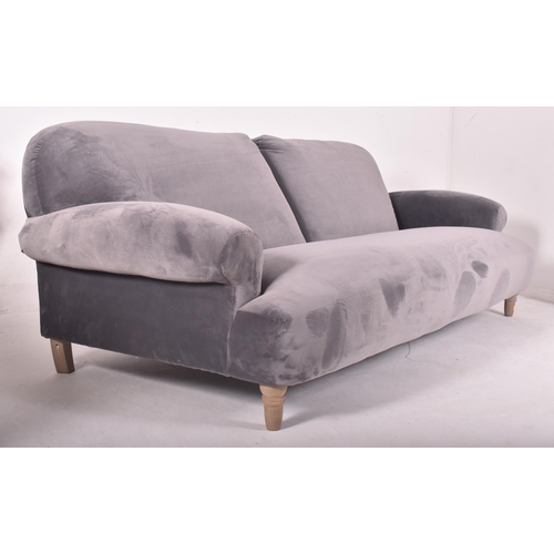 295 - A large contemporary designer four seater sofa settee. The sofa having a scrolled back and armrests ... 