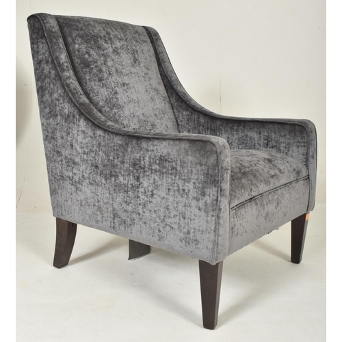 310 - A contemporary British Design armchair. The chair having a padded seat and backrest with low armrest... 