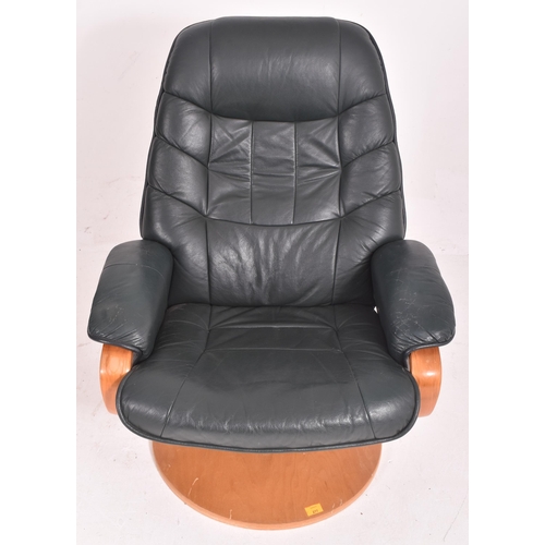 353 - A 20th century green leather upholstered swivel lounge chair / armchair and matching footstool. The ... 