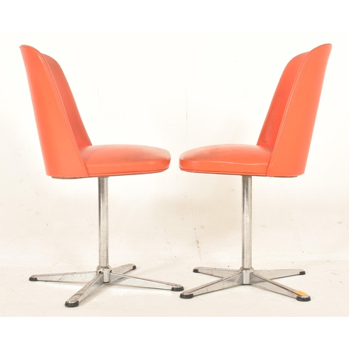 381 - A pair of retro late 20th century orange leatherette swivel office chairs. Each having a curved back... 