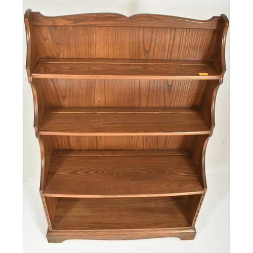 444 - Ercol - a retro 20th century elm open waterfall bookcase. The bookcase having three stepped shelves ... 