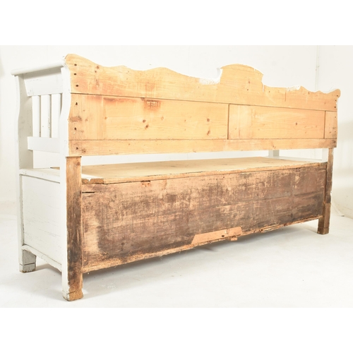 505 - A 19th century farmhouse painted pine hall settle bench. The bench having a panelled back with shape... 