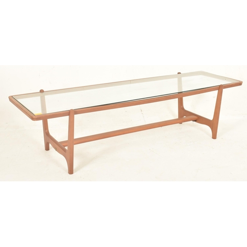 516 - A retro 20th century glass & teak wood long john low occasional coffee table. The table having a... 