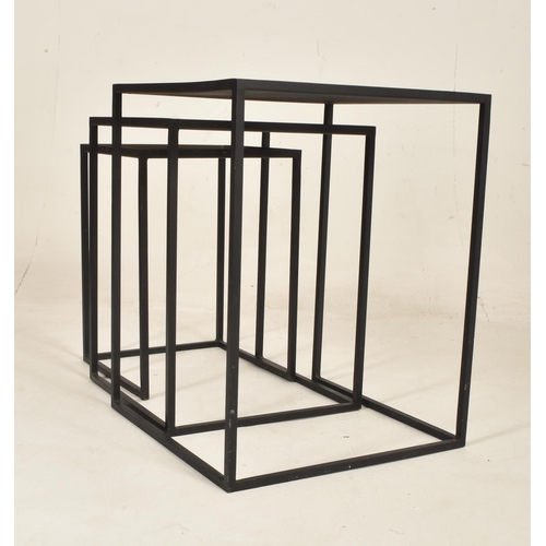 552 - A set of British Modern Design metal nesting tables. The nest of three tables of square form with ye... 