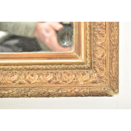 563 - An early 20th century gilt wood and gesso hanging wall mirror. The mirror having a decorative foliat... 