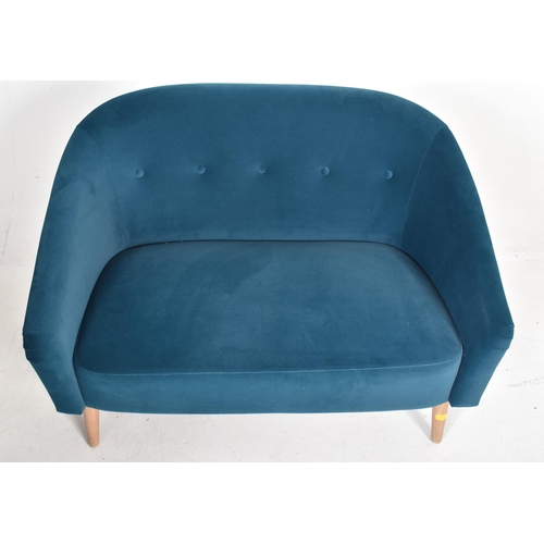 573 - A contemporary designer two seater sofa settee. The sofa having a curved button back backrest termin... 