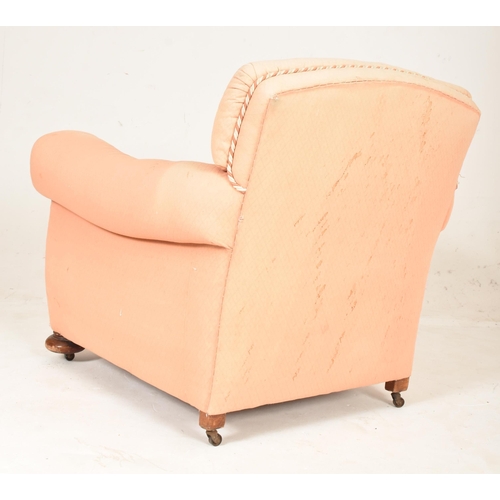 582 - An early 20th century club armchair. The chair having a padded backrest and cushioned seat with thic... 