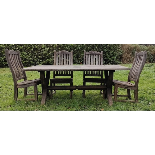 593 - A modern garden table and chairs. The slatted table raised on X-frame supports united by a single st... 