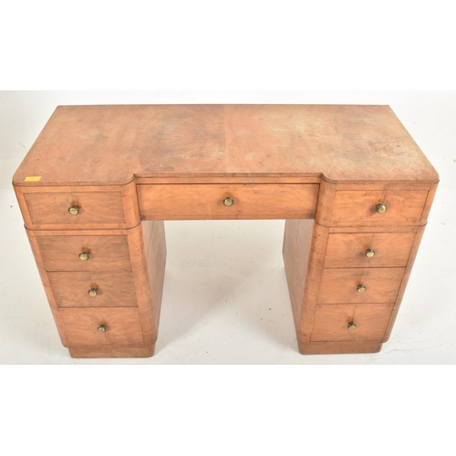 97 - A 20th century Art Deco walnut pedestal writing table desk. The desk having an inverted breakfront t... 