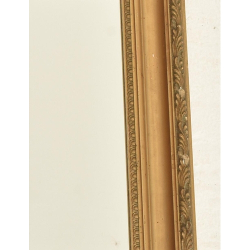 571 - An early 20th century gilt wood and gesso framed hanging mirror. The mirror of rectangular form with... 