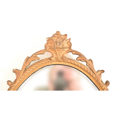 589 - A vintage mid century gilt framed hanging mirror. The mirror of oval form having acanthus pierced mo... 