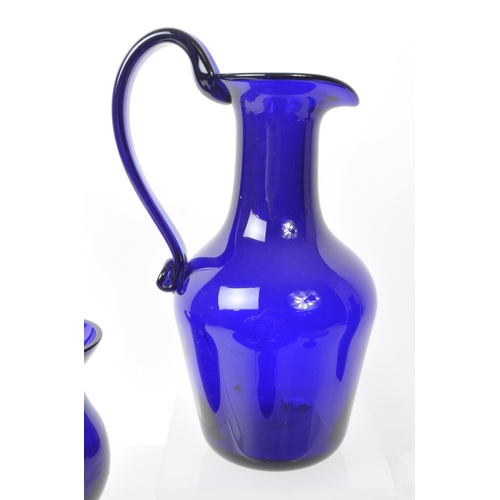 101 - A collection of 20th century Bristol blue studio art glass. The collection to include jugs, vases, b... 