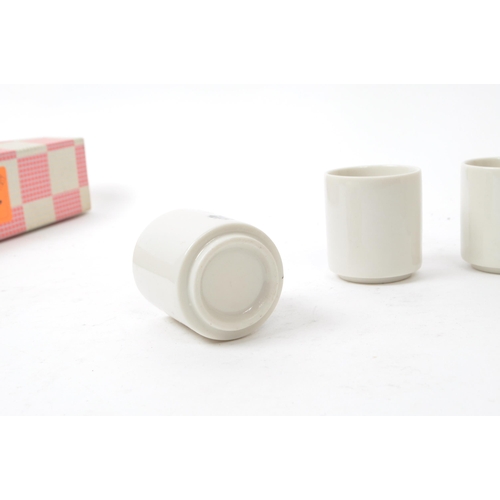 115 - A set of five mid-century Japanese Kabuki style sake / shot porcelain cups, housed within their orig... 