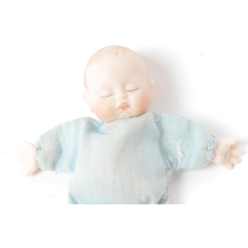 166 - A 20th century miniature bisque baby doll, stamped behind the head 'JSD', featuring a blue clothed b... 