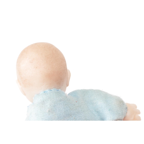 166 - A 20th century miniature bisque baby doll, stamped behind the head 'JSD', featuring a blue clothed b... 