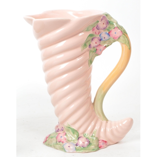 183 - Clarice Cliff - A collection of two mid century Newport pottery vases, comprised of a pink Cornucopi... 