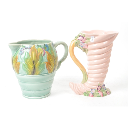 183 - Clarice Cliff - A collection of two mid century Newport pottery vases, comprised of a pink Cornucopi... 