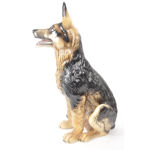 191 - A 20th century vintage porcelain German Shepherd figurine. The figurine being modelled panting in se... 